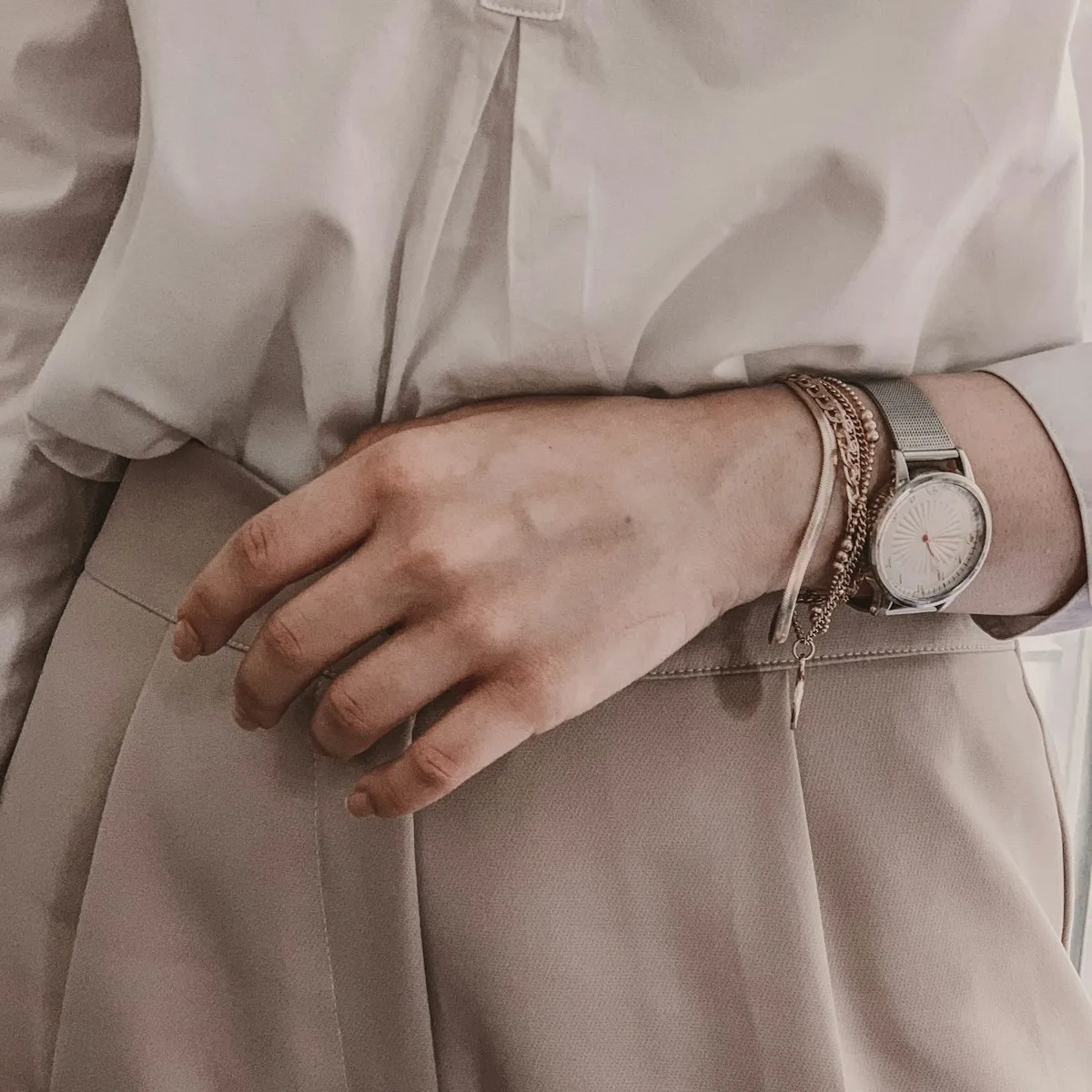 Editorial fashion detail — cream silk outfit with watch — bobbie.ai personal styling